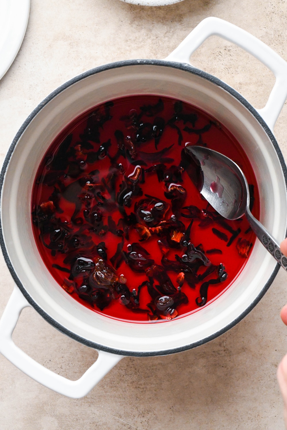 How to make hibiscus lemonade: Dried hibiscus flowers after steeping in hot water and agave - syrup is bright red.