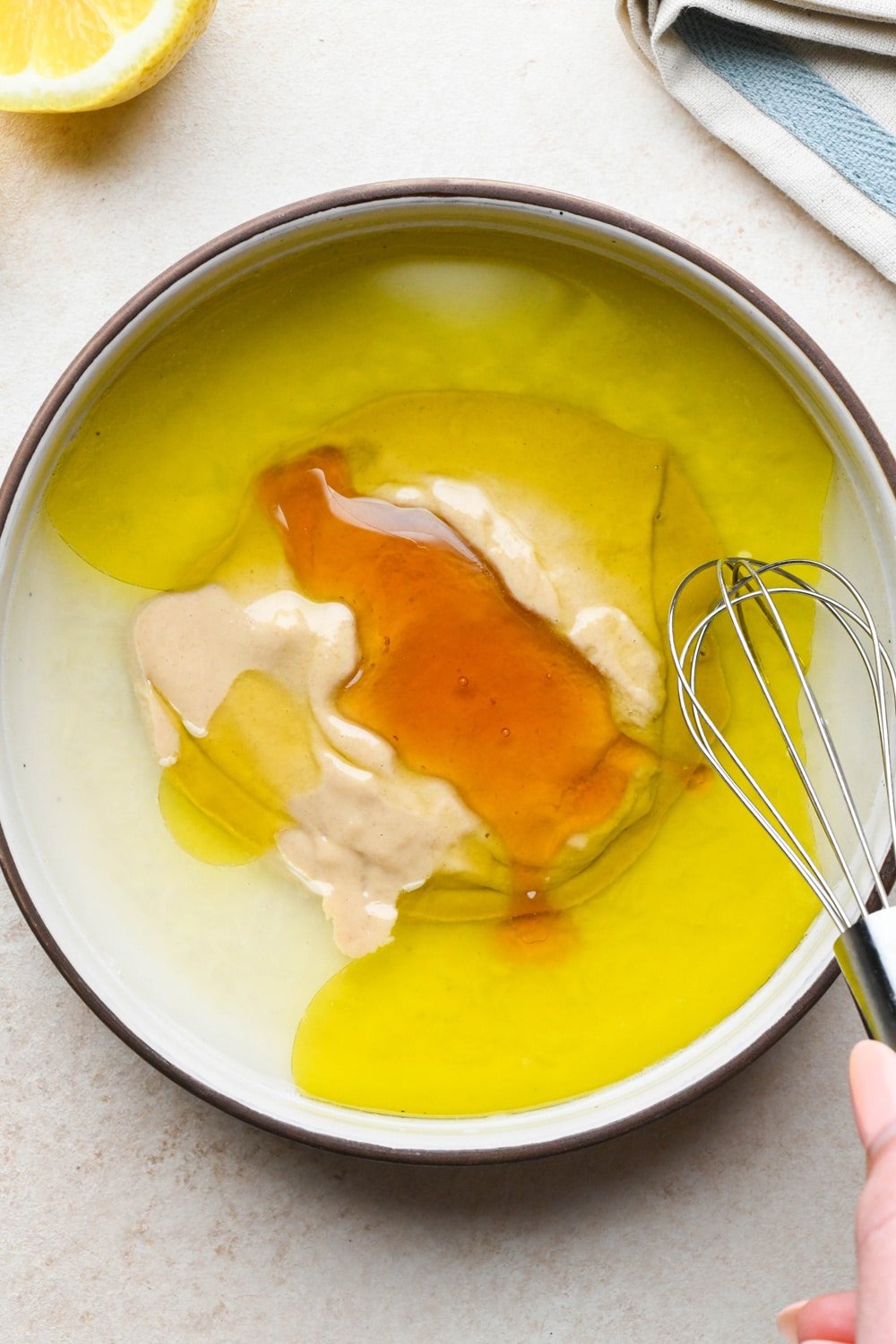 How to make tahini dressing: Tahini, honey, olive oil, and water added to the bowl with the other dressing ingredients.