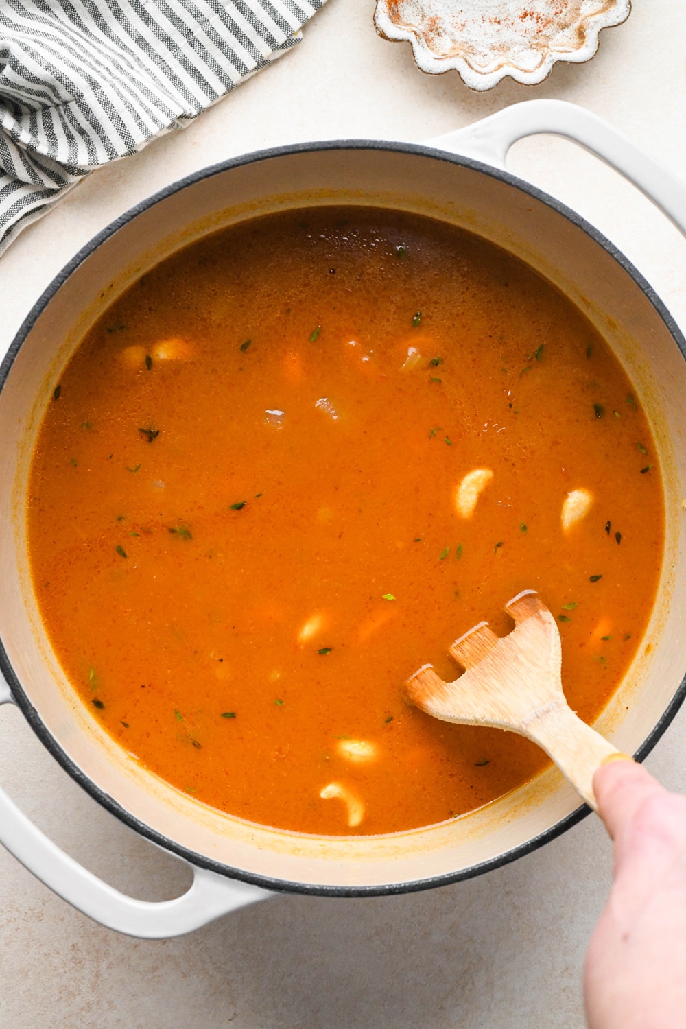 How to make Dairy Free Pumpkin Carrot Soup: Mixing the pumpkin puree, cashews, and vegetable broth together in the soup pot.