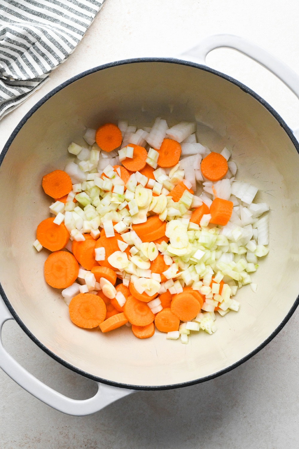 How to make Dairy Free Pumpkin Carrot Soup: Onions, carrots, and fennel in soup pot with olive oil before sautéing.