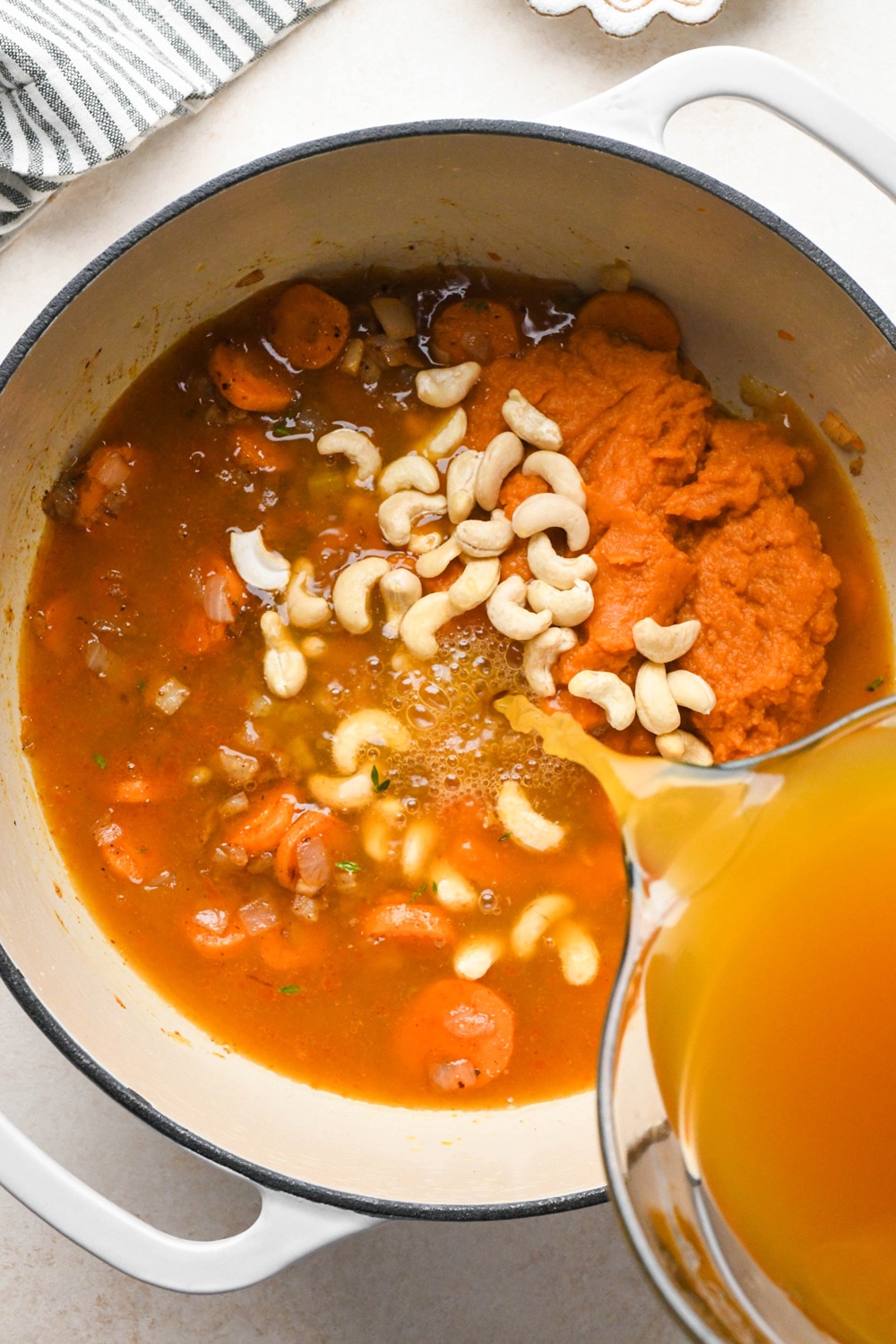 How to make Dairy Free Pumpkin Carrot Soup: Pouring vegetable broth into the soup pot.