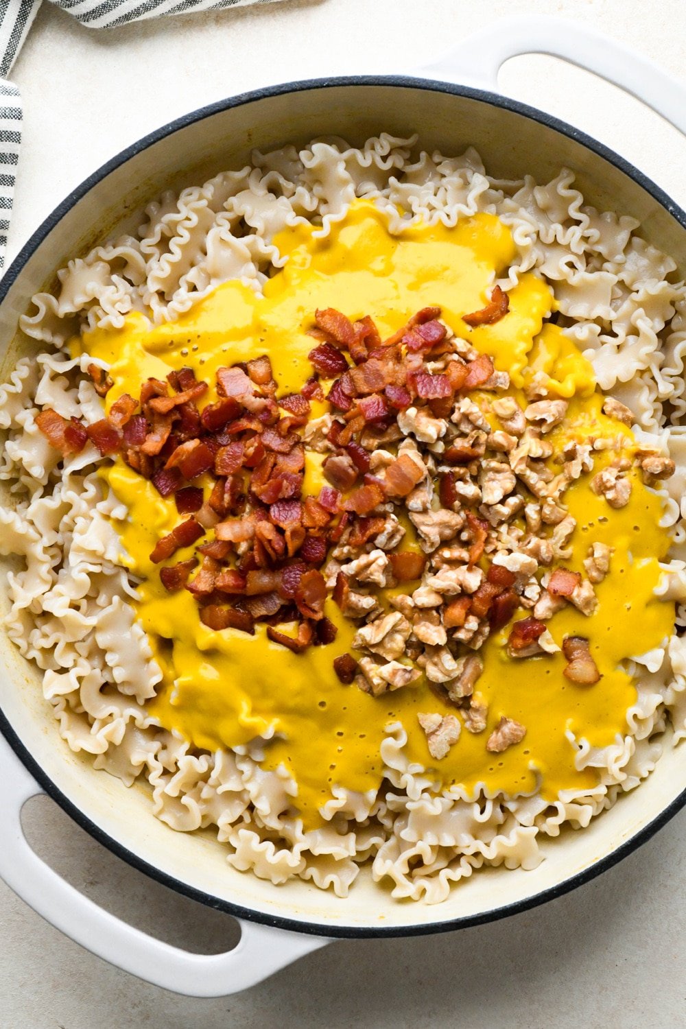 How to make Dairy Free Butternut Squash Pasta: Pasta, pasta sauce, bacon, and walnuts added back to the skillet, before stirring.