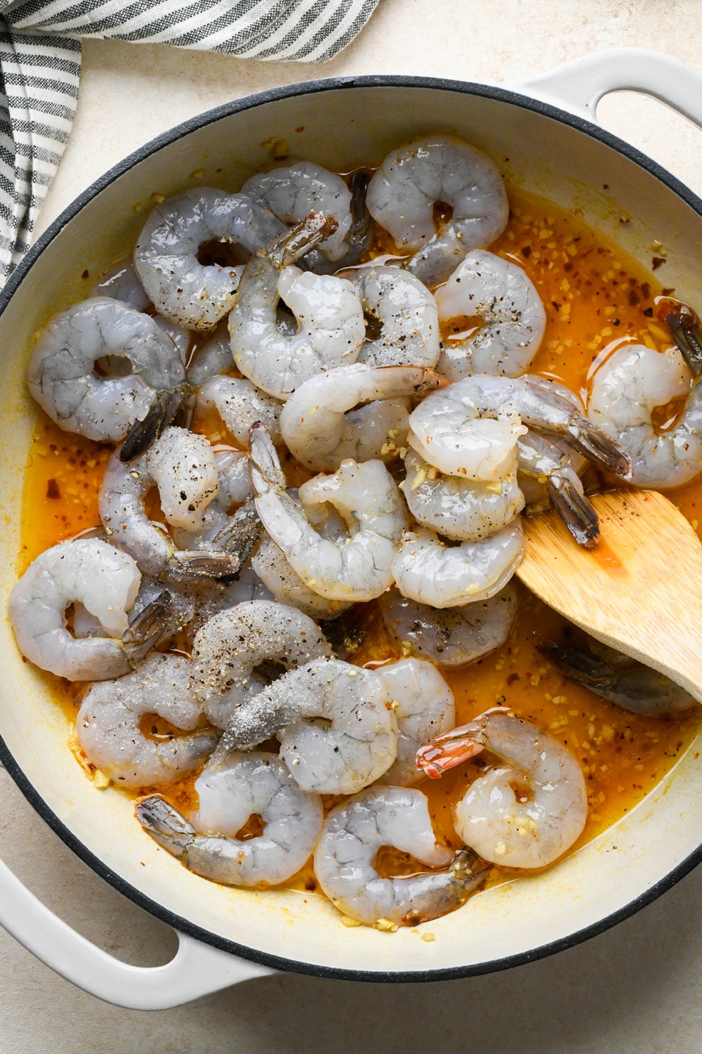 How to make Shrimp Scampi Without Wine: Raw shrimp in the skillet with salt and pepper.