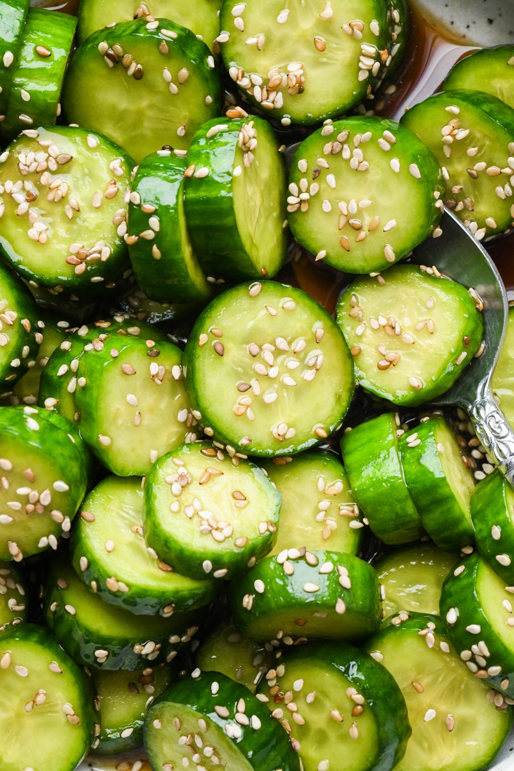 Close up shot of prepared cucumber sesame salad, topped with sesame seeds.