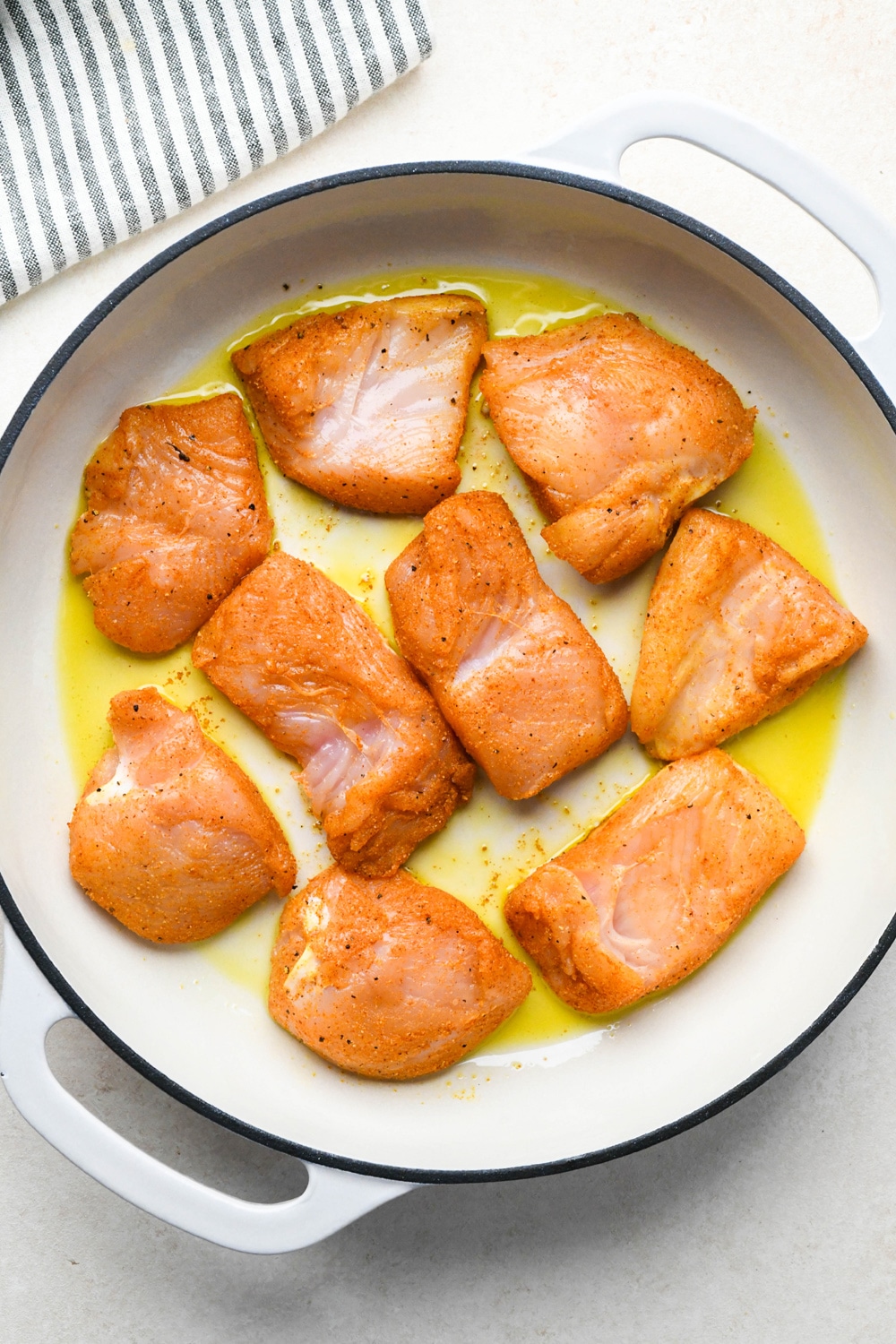 How to make curry chicken and rice: Chicken breast pieces cooking in a skillet in olive oil.