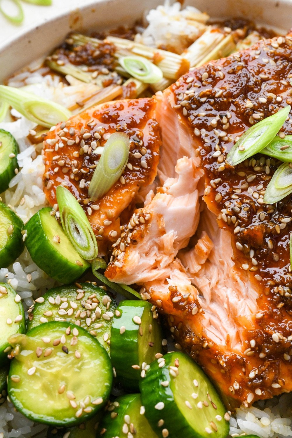 A close up of glazed garlic ginger salmon, the flesh flaked to show the perfectly cooked interior.