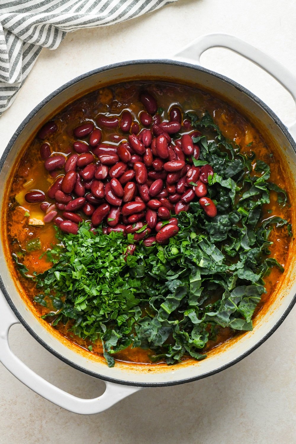How to make Gluten Free Minestrone Soup: Kidney beans, chopped lacinato kale, and chopped fresh parsley added to the soup before cooking.