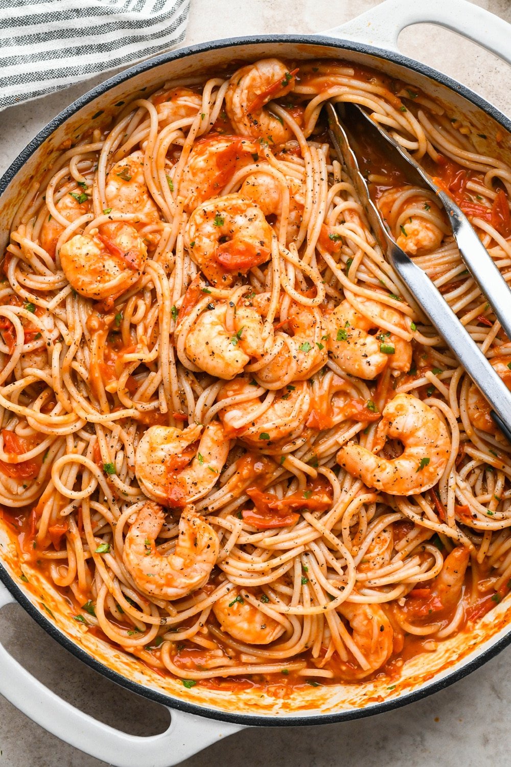 How to make Burst Cherry Tomato Shrimp Pasta: Cooked pasta and fresh parsley added to the skillet, after tossing to combine.