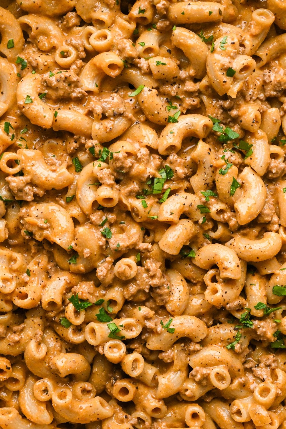 A close up of the noodles in creamy dairy free hamburger helper topped with fresh parsley and black pepper.