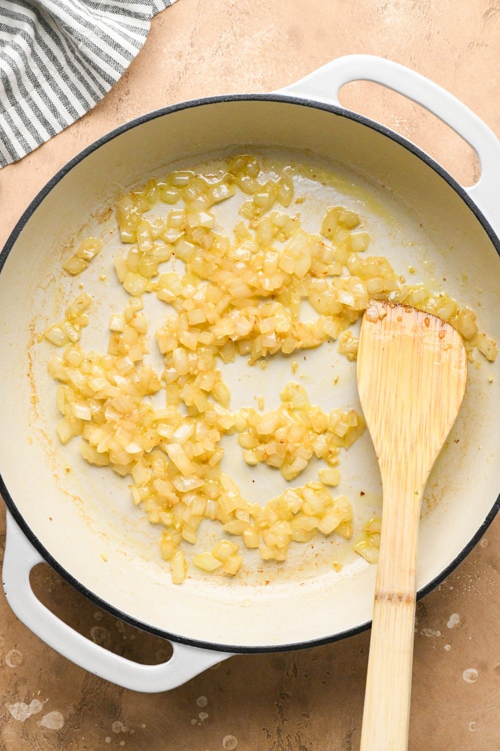 How to make dairy free hamburger helper: Olive oil, diced onions, and chopped garlic in a large white ceramic coated cast iron skillet - after sautéing until caramelized.