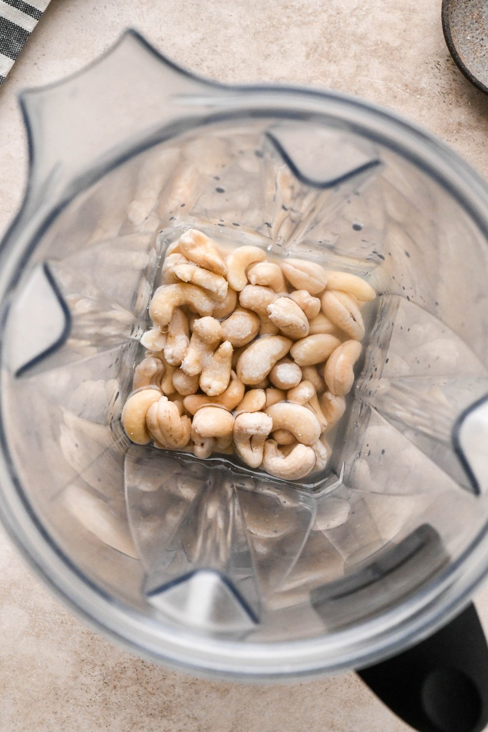 How to make dairy free tzatziki: Soaked cashews in the container of a Vitamix blender before blending with lemon juice apple cider vinegar, and kosher salt.