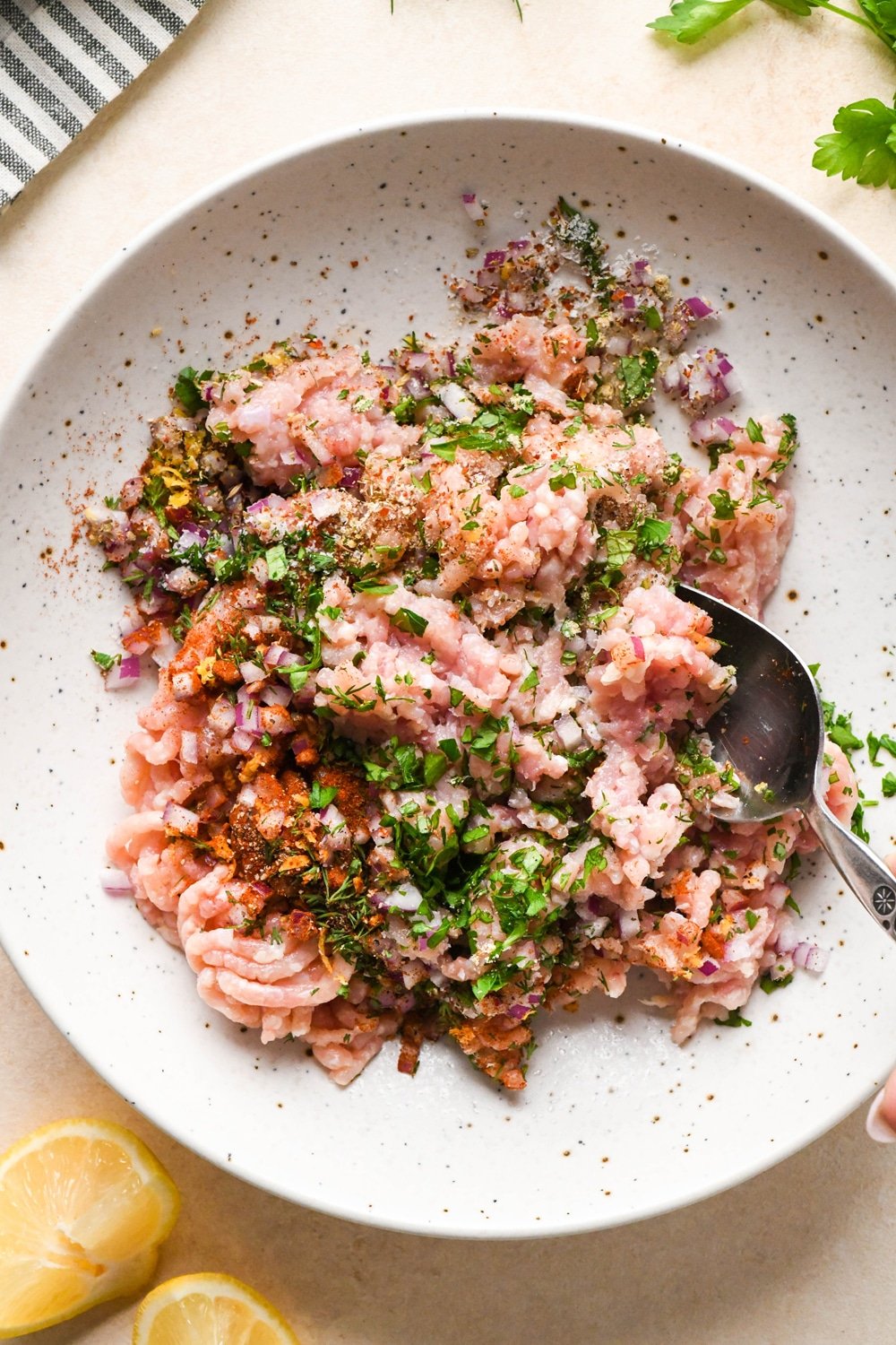 How to make Greek chicken meatballs: Ingredients for meatballs in a large bowl, during mixing.