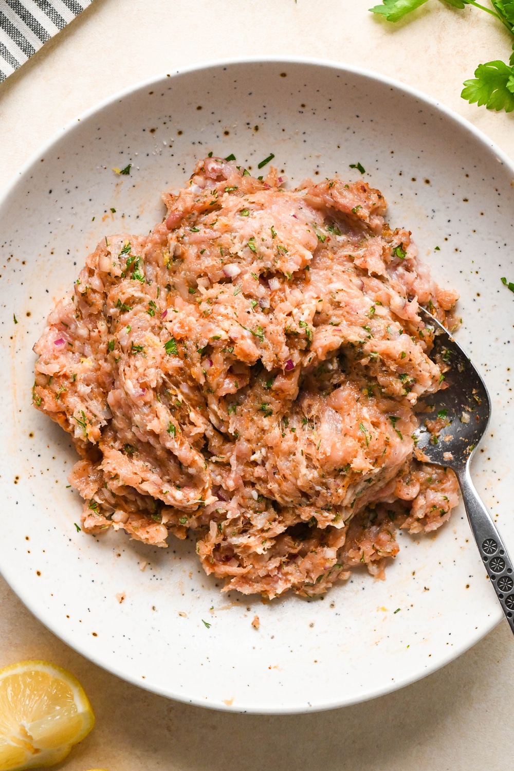 How to make Greek chicken meatballs: Ingredients for meatballs in a large bowl, after mixing together.