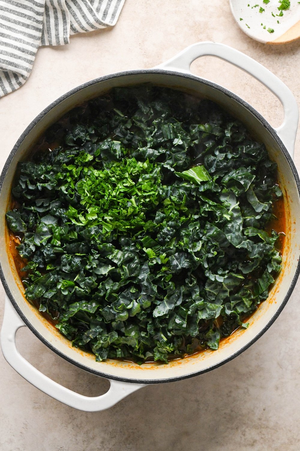 How to make Brothy Sausage and Potato Soup with Kale and Cabbage: Chopped kale and parsley added to the pot before cooking.