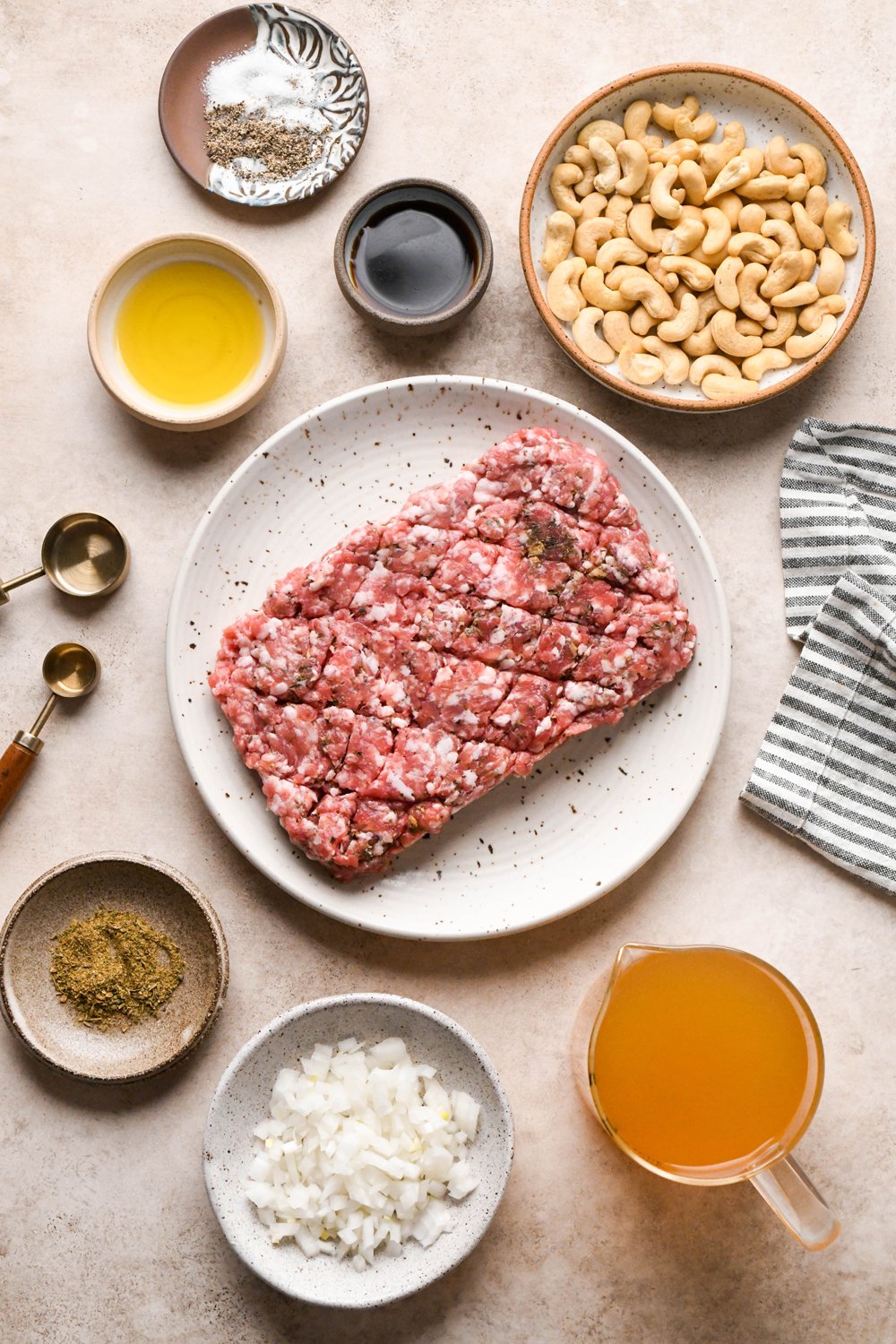 Ingredients for gluten free sausage gravy in various ceramics on a light brown background.