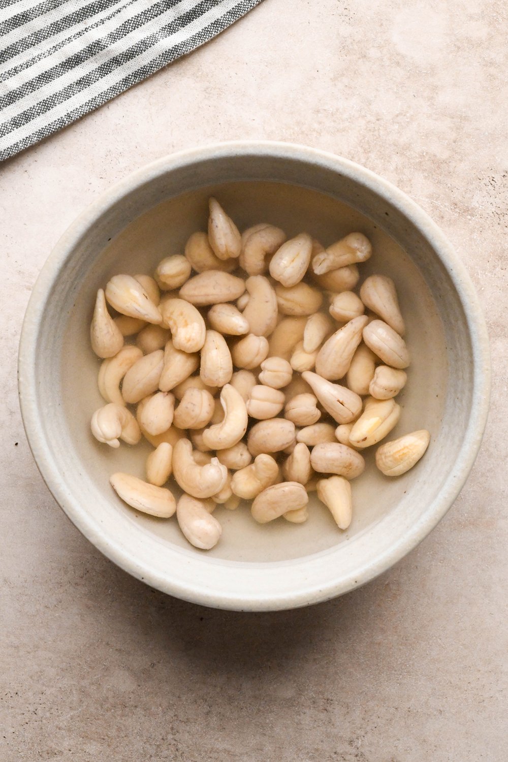 How to make Gluten Free Sausage Gravy: Cashew in ceramic bowl after soaking, looking more pale and plump.