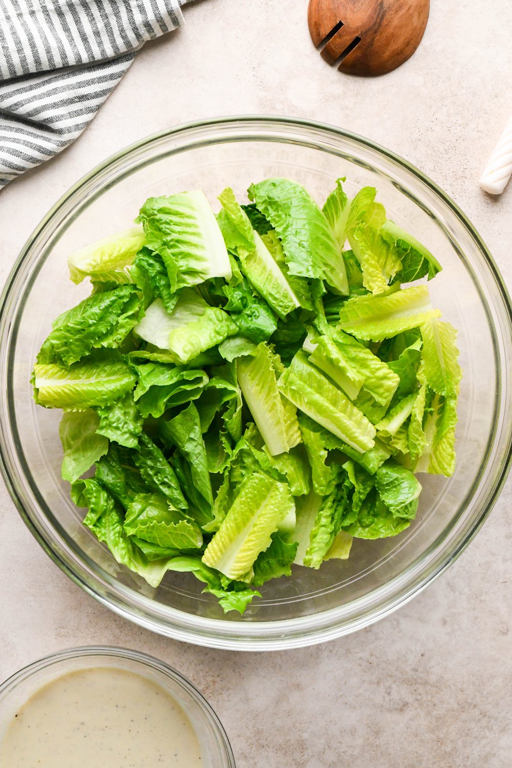How to make a Caesar Salad with gluten free breadcrumbs: Cut romaine lettuce in a large glass bowl. 