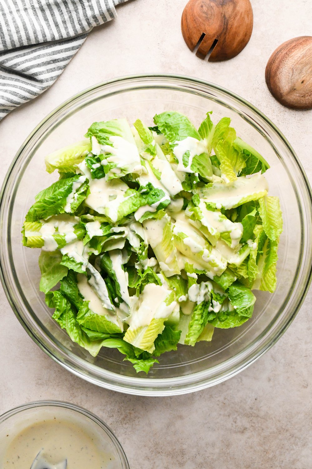How to make a Caesar Salad with gluten free breadcrumbs: Cut romaine lettuce in a large glass bowl, with Caesar dressing drizzled on top. 
