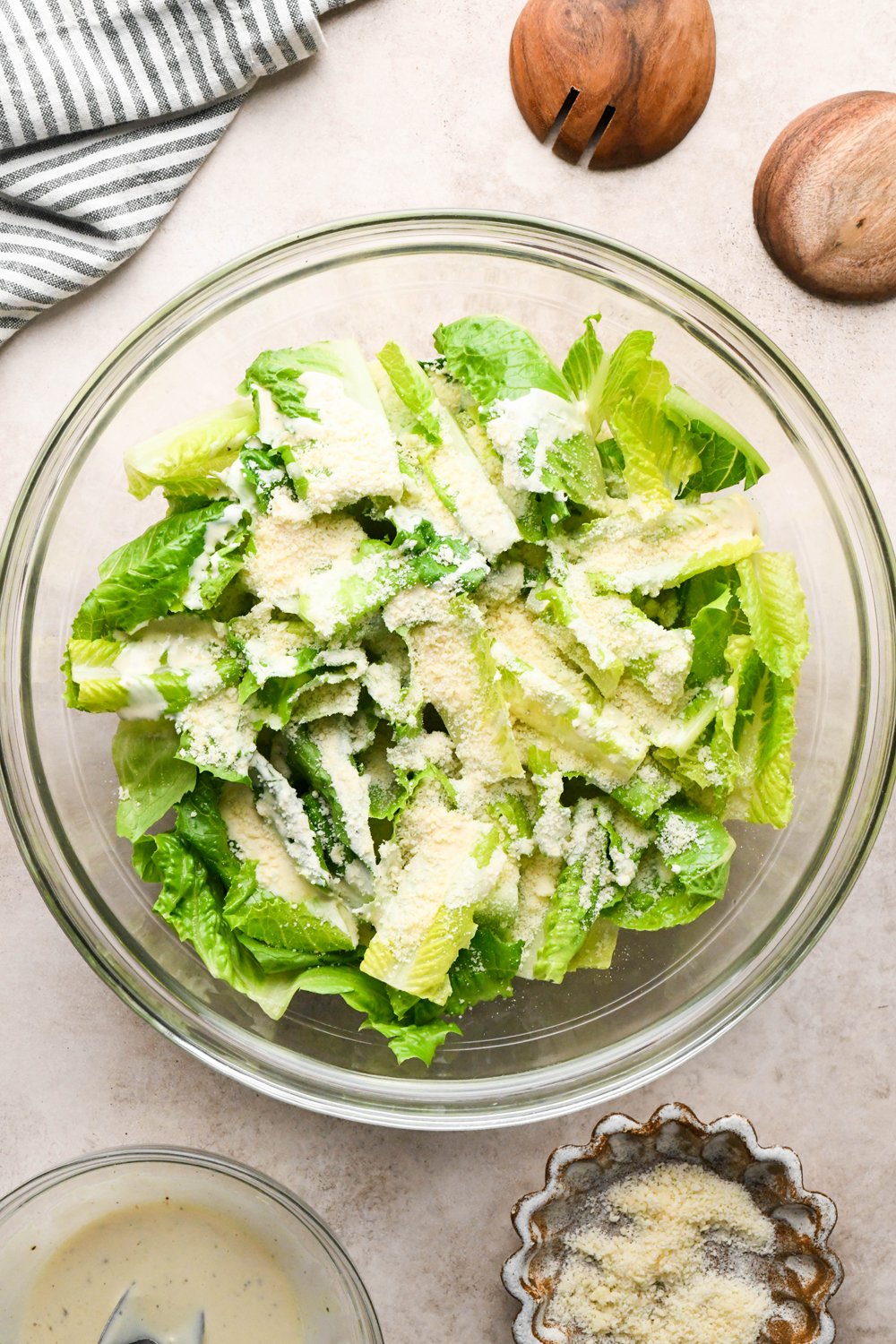 How to make a Caesar Salad with gluten free breadcrumbs: Cut romaine lettuce in a large glass bowl, with Caesar dressing drizzled on top and grated Parmesan cheese added to the lettuce as well.