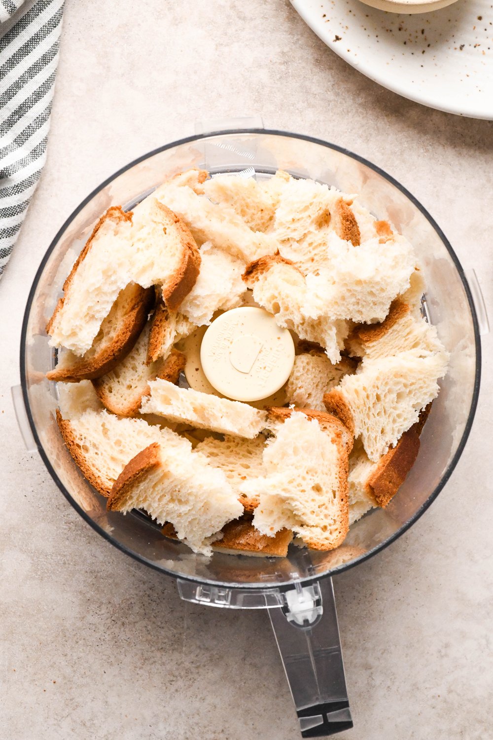 How to make a Caesar Salad with gluten free breadcrumbs: Gluten free bread torn into 2-inch sized pieces in the container of a food processor, before processing.
