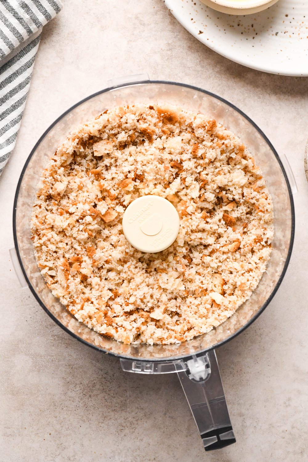 How to make a Caesar Salad with gluten free breadcrumbs: Gluten free bread in the container of a food processor after pulsing into coarse bread crumbs.