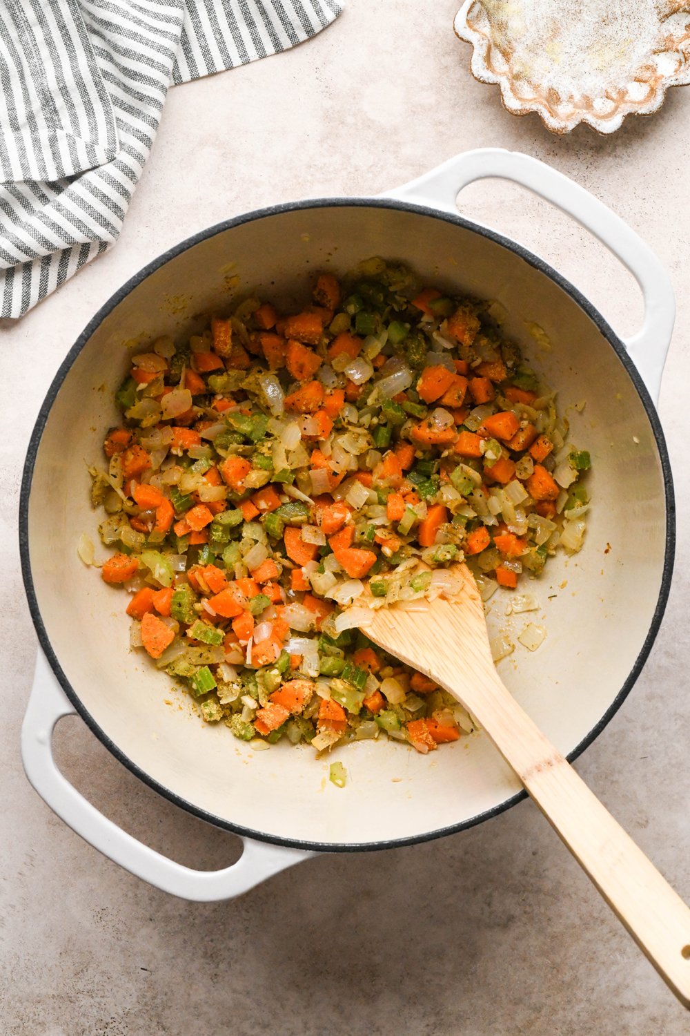 How to make Chicken and Broccoli Soup: Spices and nutritional yeast stirred into the sautéed veggies in a large off-white ceramic soup pot. 