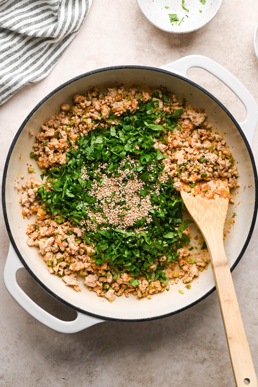 How to make garlic scallion noodles: Scallions, garlic, and chili flakes stirred into the ground chicken and cilantro and sesame seeds added to the skillet.