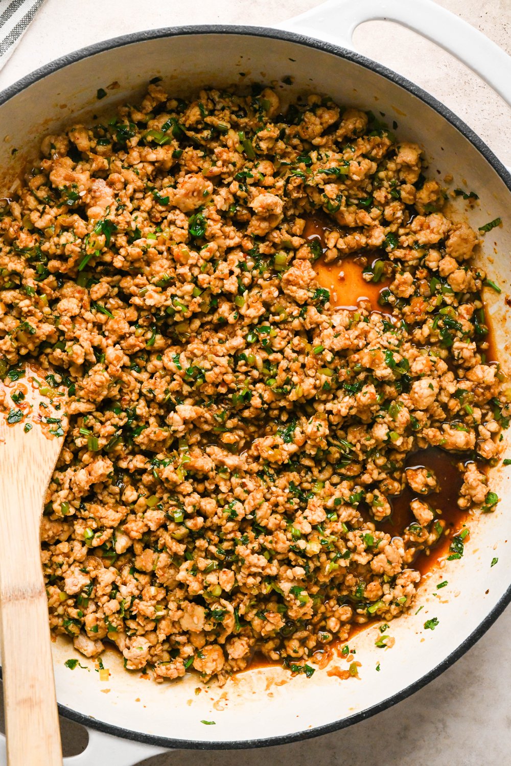 How to make garlic scallion noodles: Ground chicken sauce in the skillet after briefly simmering the liquid that was added.
