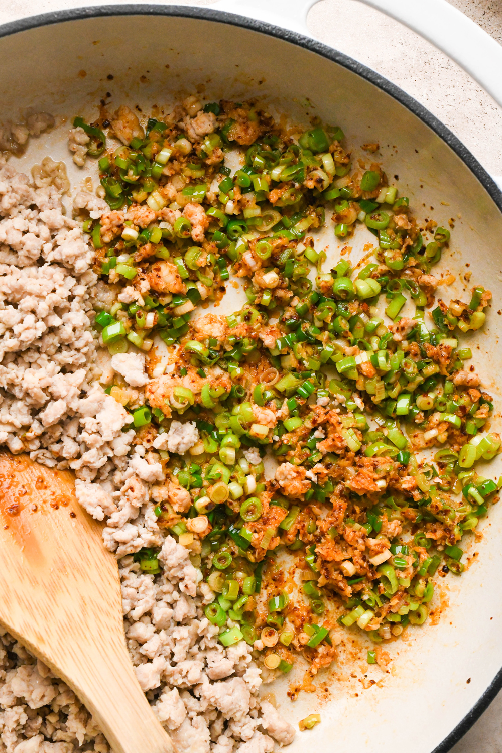 How to make garlic scallion noodles: Close up image of the sautéed scallions, garlic, and chili flakes in the skillet.