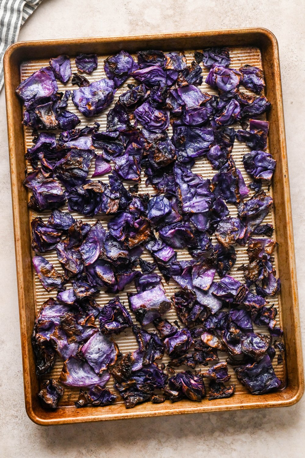 How to make Roasted Chopped Red Cabbage with Olive Oil: Cabbage pieces after they have been roasted. The cabbage appears soft and tender, with crispy edges.